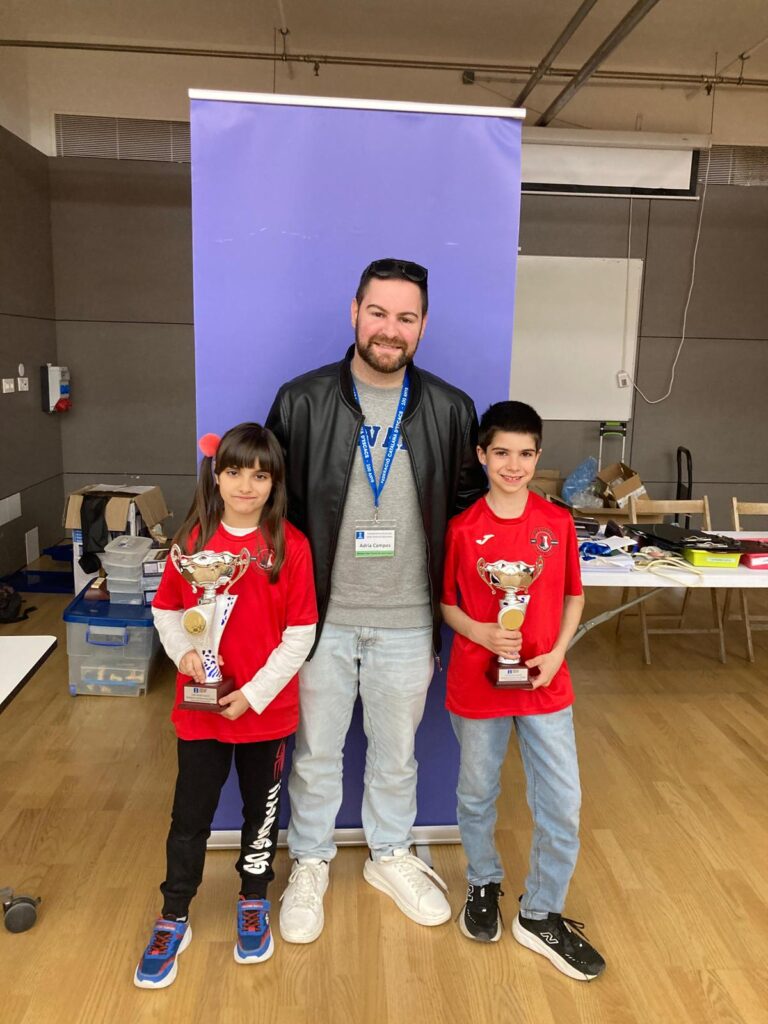 Laia Cid i Alexander Jiménez, jugadors del Club d’Escacs Dos Torres, amb el seu entrenador després de guanyar el podi al Campionat de Barcelona 2025